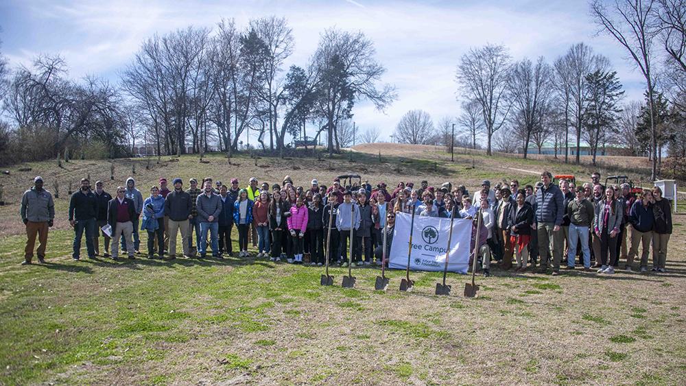 Arbor Day celebrants from Mississippi State and Partnership Middle School pose in front of shovels.