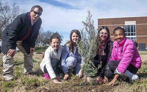 Wes Burger poses with Partnership Middle School students Molly Camp, Becky Brasher, Lyla Harrelson and Khloe Hendrix during Arbor Day celebrations at Partnership Middle School.