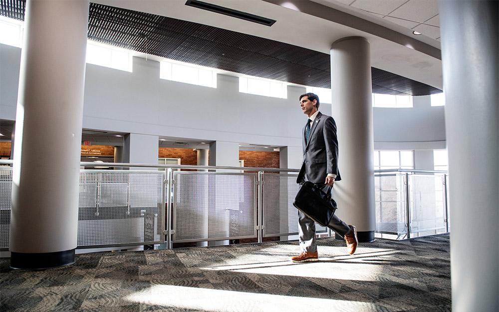 Associate Professor of Finance Brian Blank walking in McCool Hall's Atrium