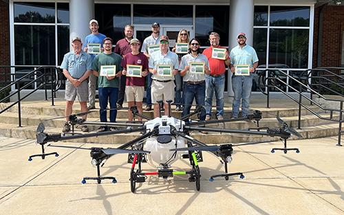 Participants of Mississippi State’s Self-Regulated Application and Flight Efficiency (S.A.F.E.) pose with certificates in front of a drone.