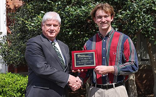 Spring 2025 Mississippi State aerospace engineering graduate Austin Prevette, of Sugarland, Texas, poses with his Mississippi Engineering Society award alongside Associate Dean of Academics Robert Green.