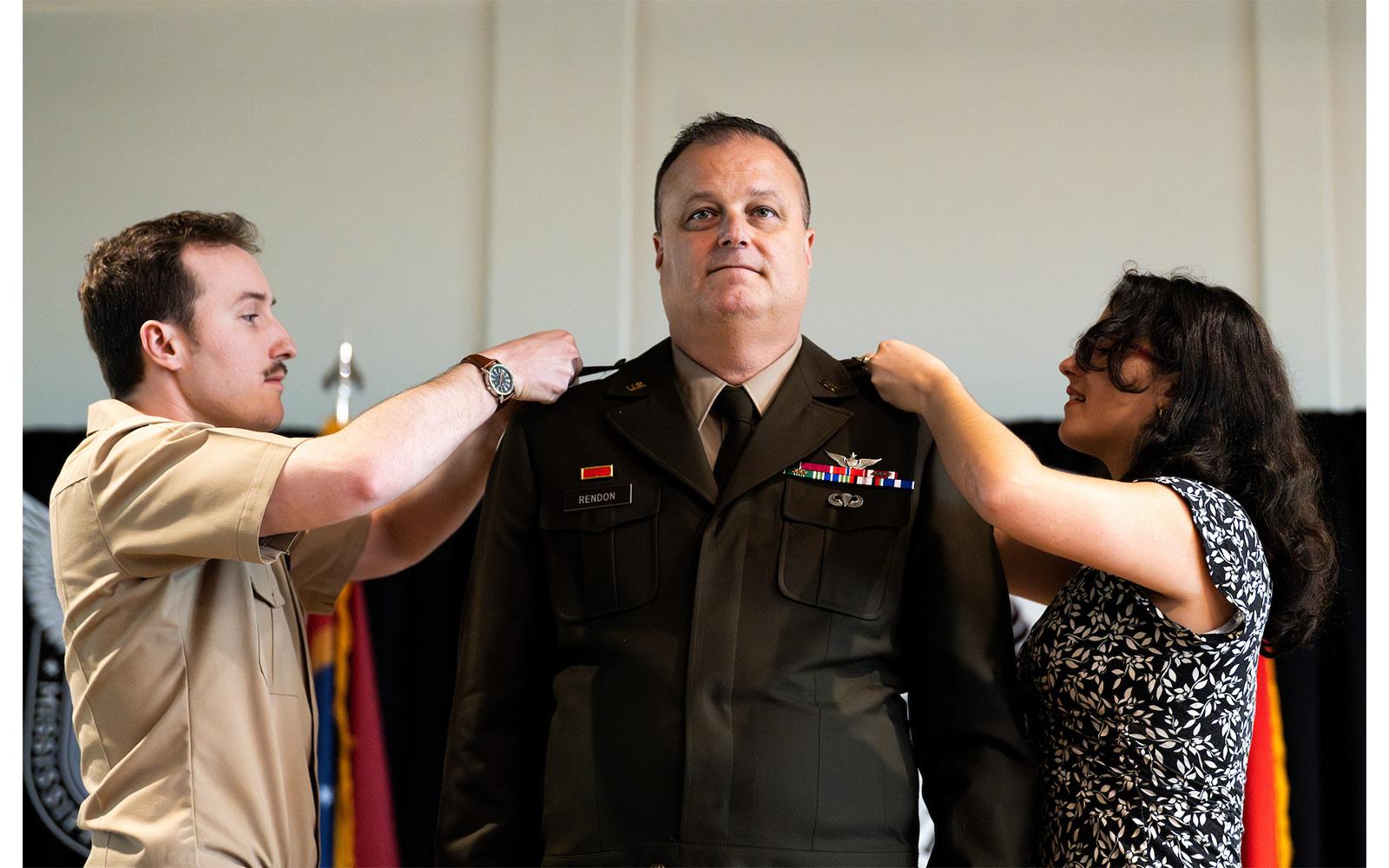 Brigadier General Andrew Rendon’s children, Kyler and Sarah Rendon, place insignia representing his new rank on his uniform during Rendon’s 2024 pinning and promotion ceremony at Mississippi State.