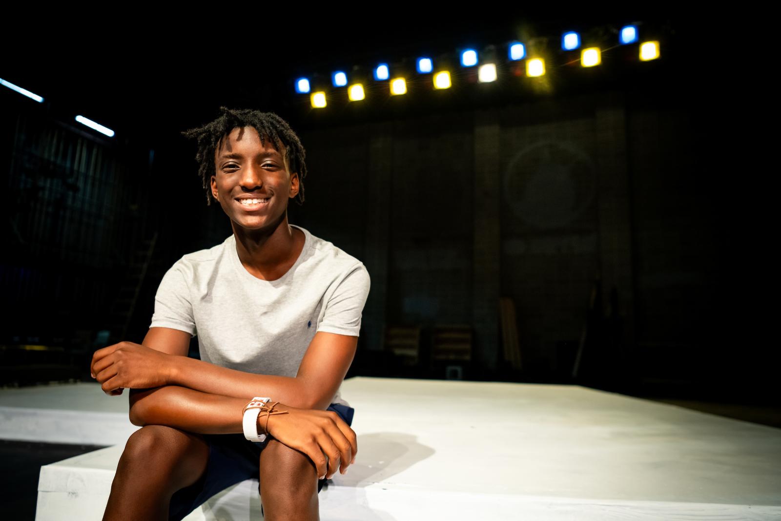 student sitting on stage