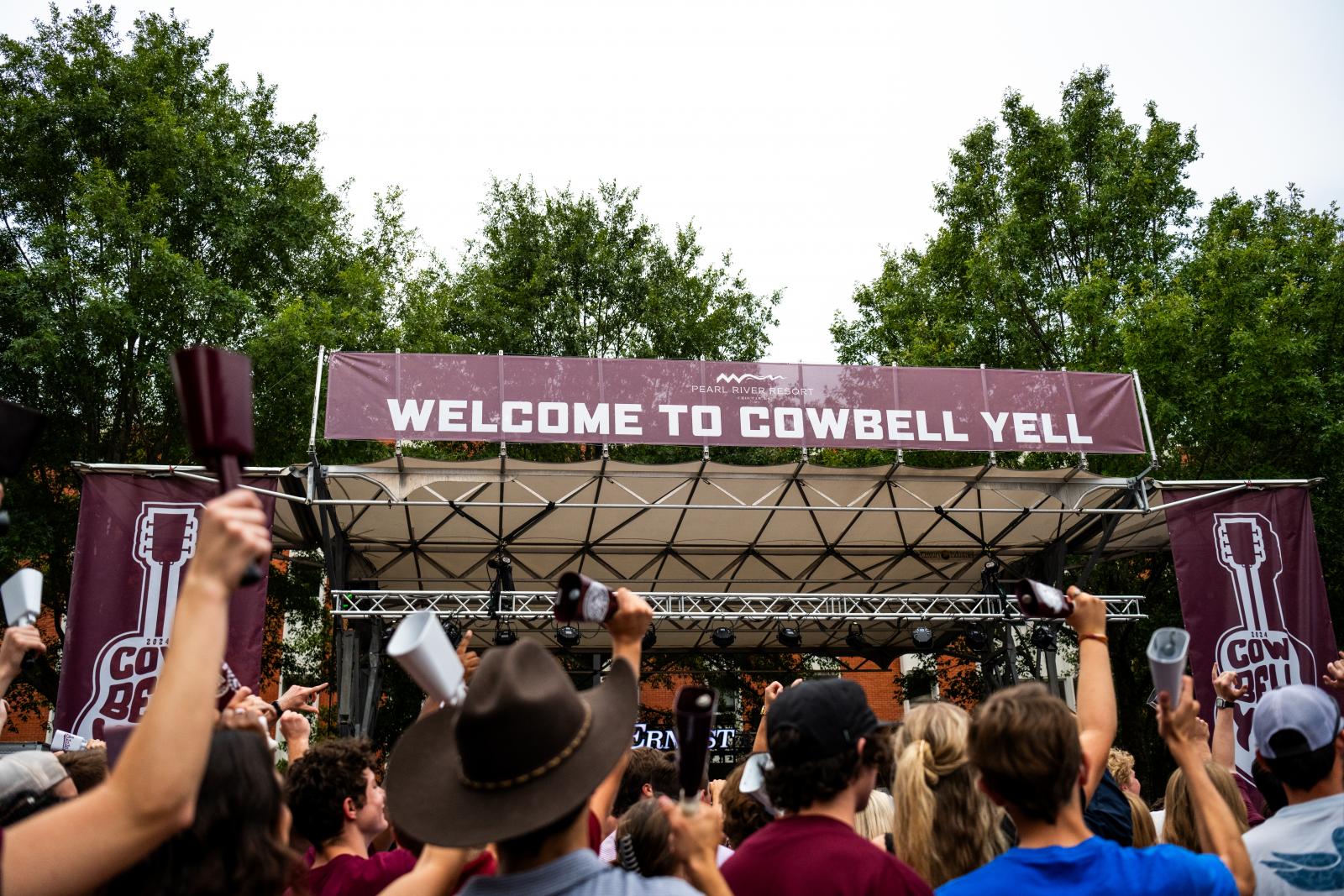 Welcome to Cowbell Yell sign and fans