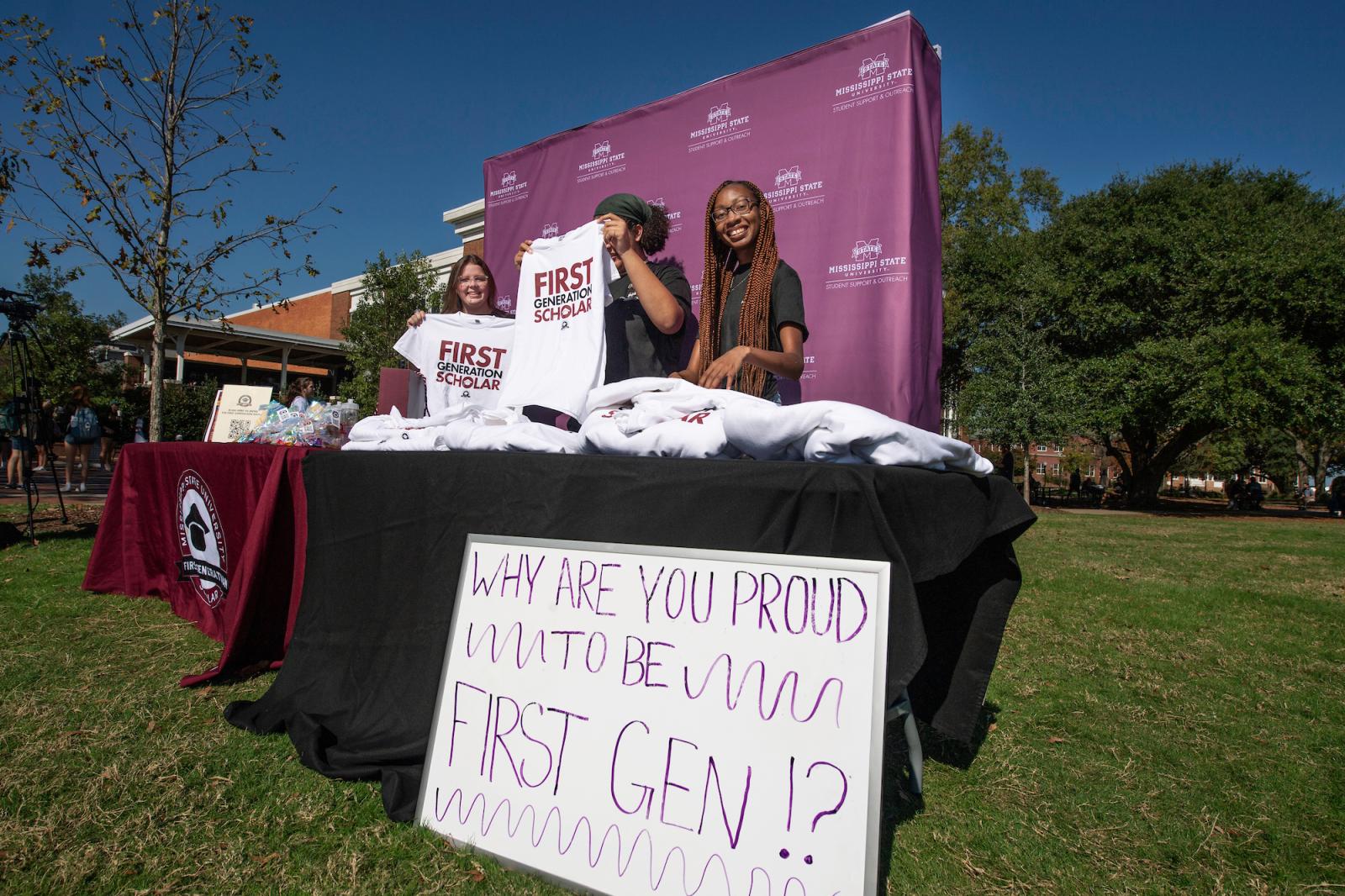 Students give away T-shirts that say First Generation Scholar.