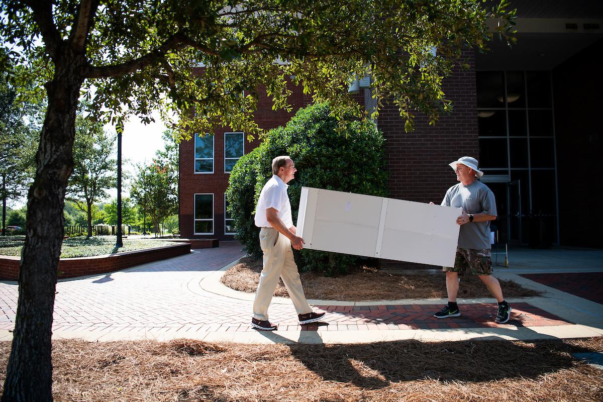 two men carrying furniture