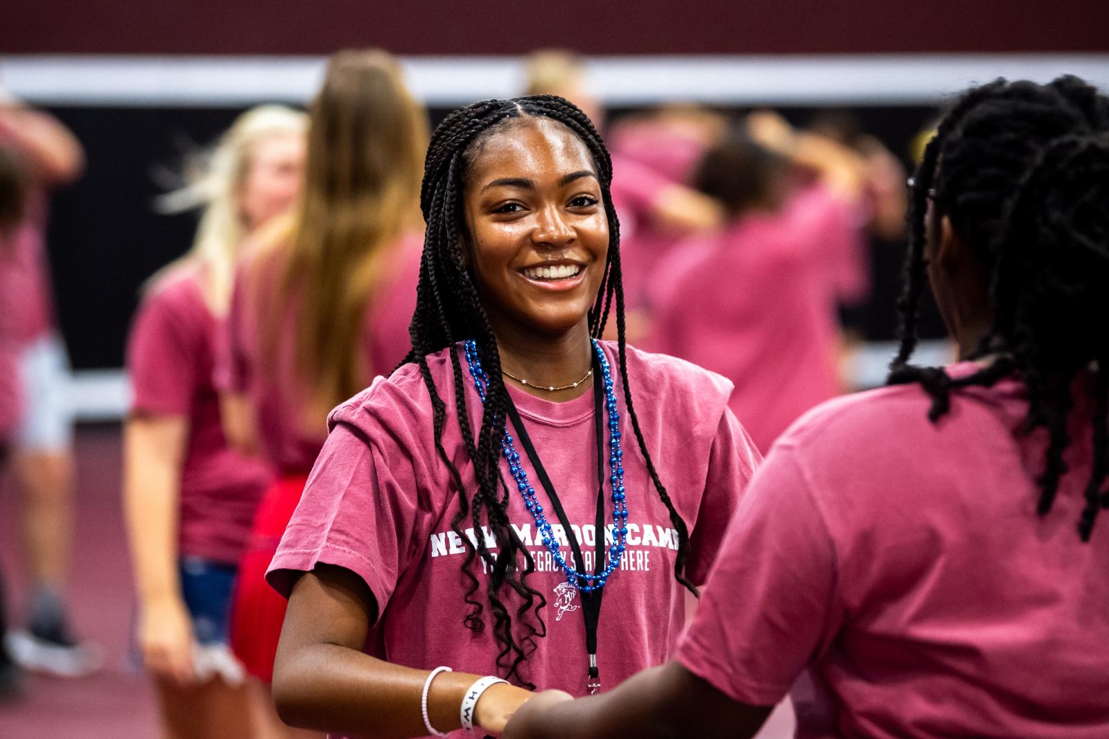 young lady smiling in a maroon shirt