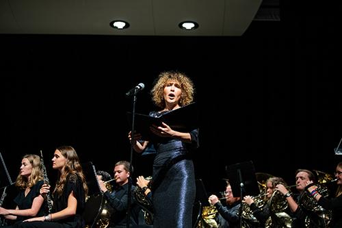 A singer performs with backing musicians.