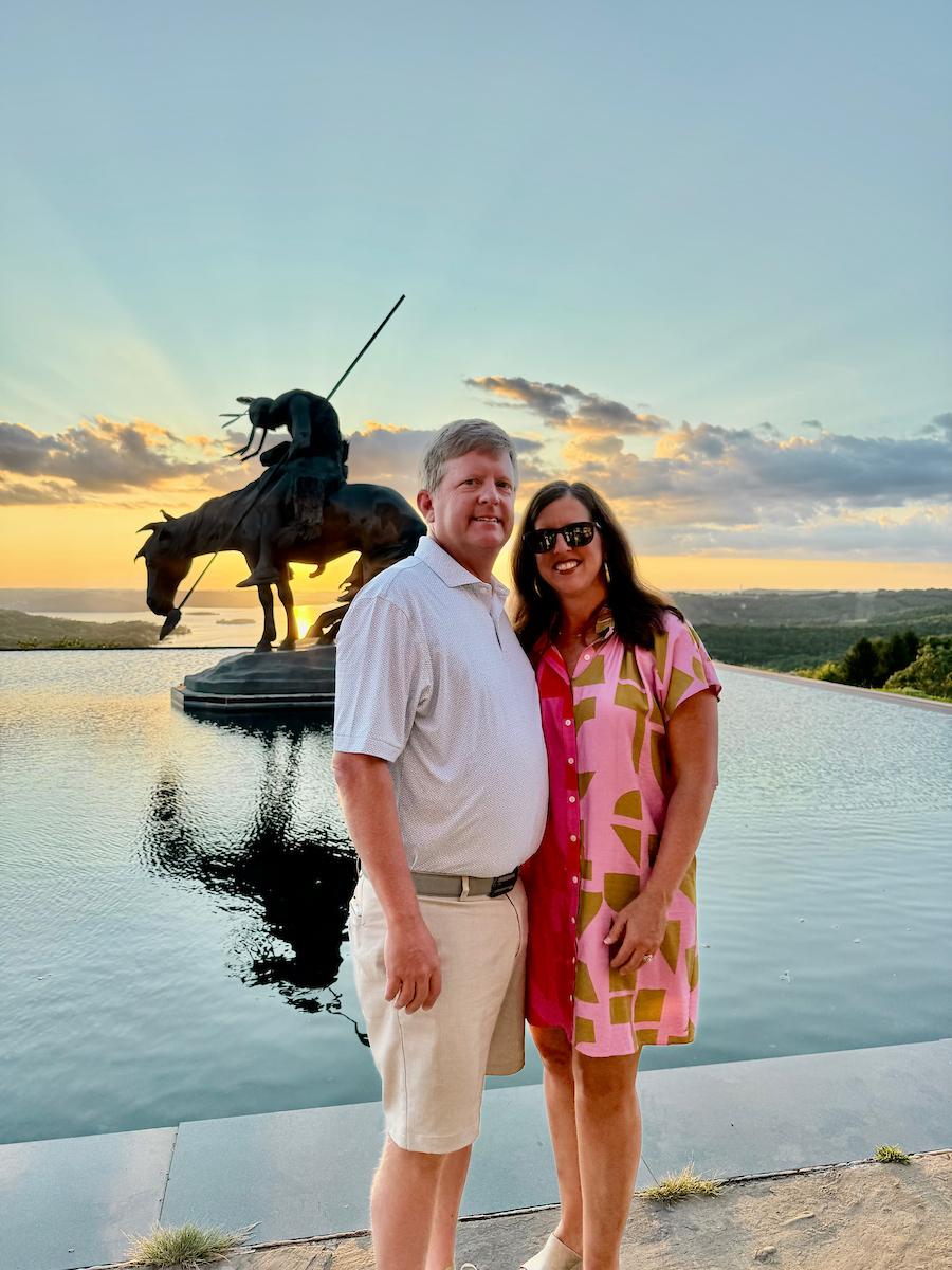 man and woman in front of horse statue