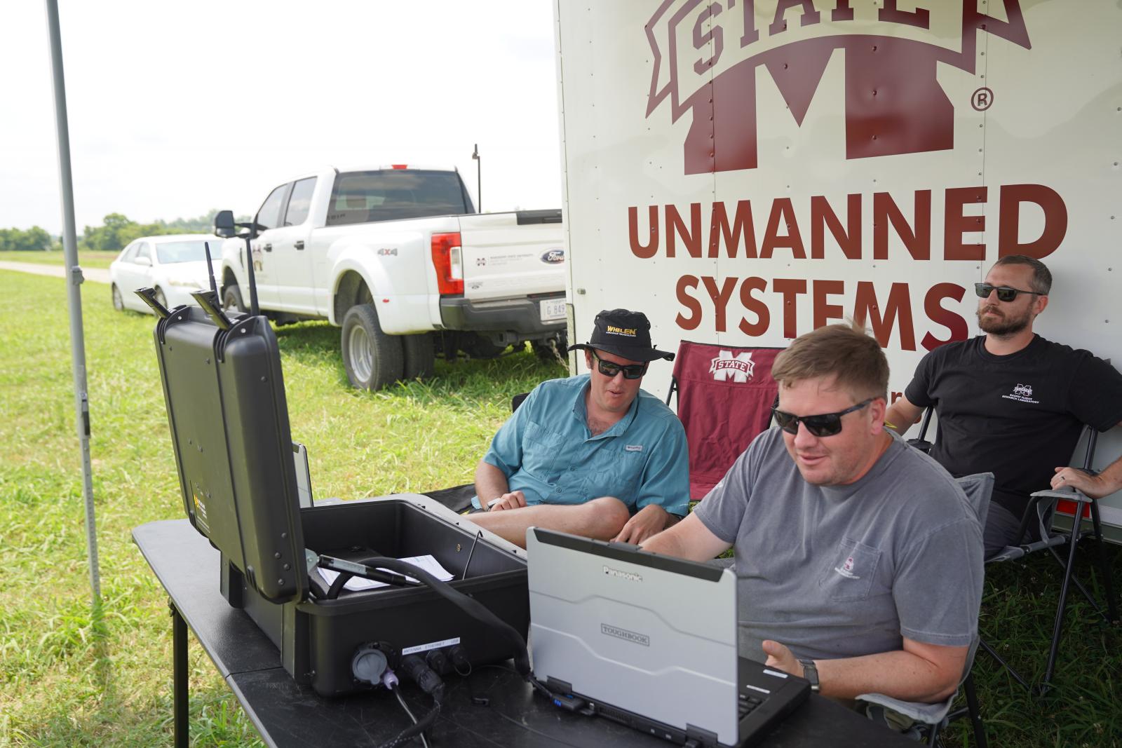 three men looking at computer