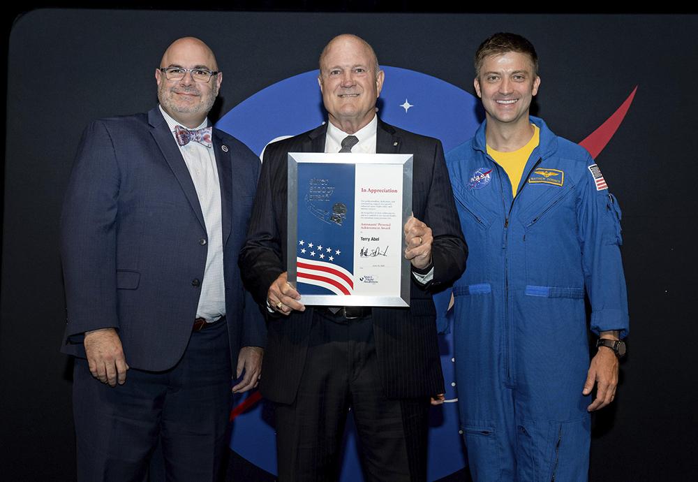Silver Snoopy Award recipient Terry Abel, center, is joined by NASA Marshall Space Flight Center Director Joseph Pelfrey, left, and Astronaut Matthew Dominick following the award presentation.