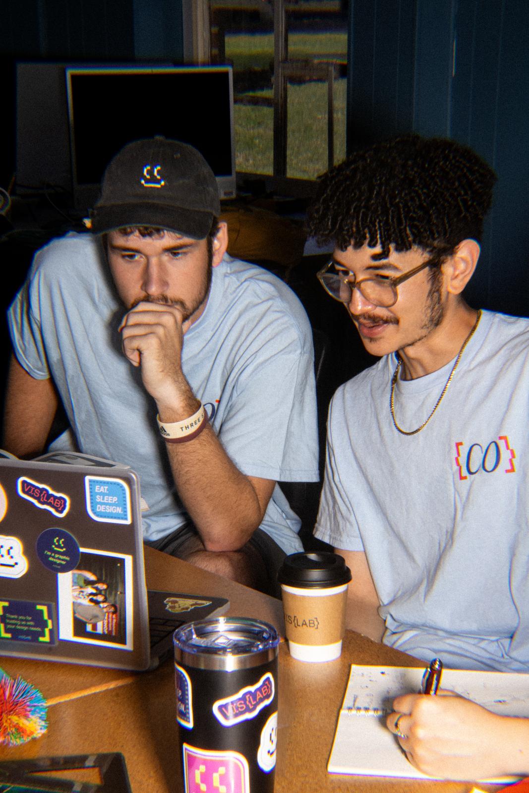 two young students work on laptop