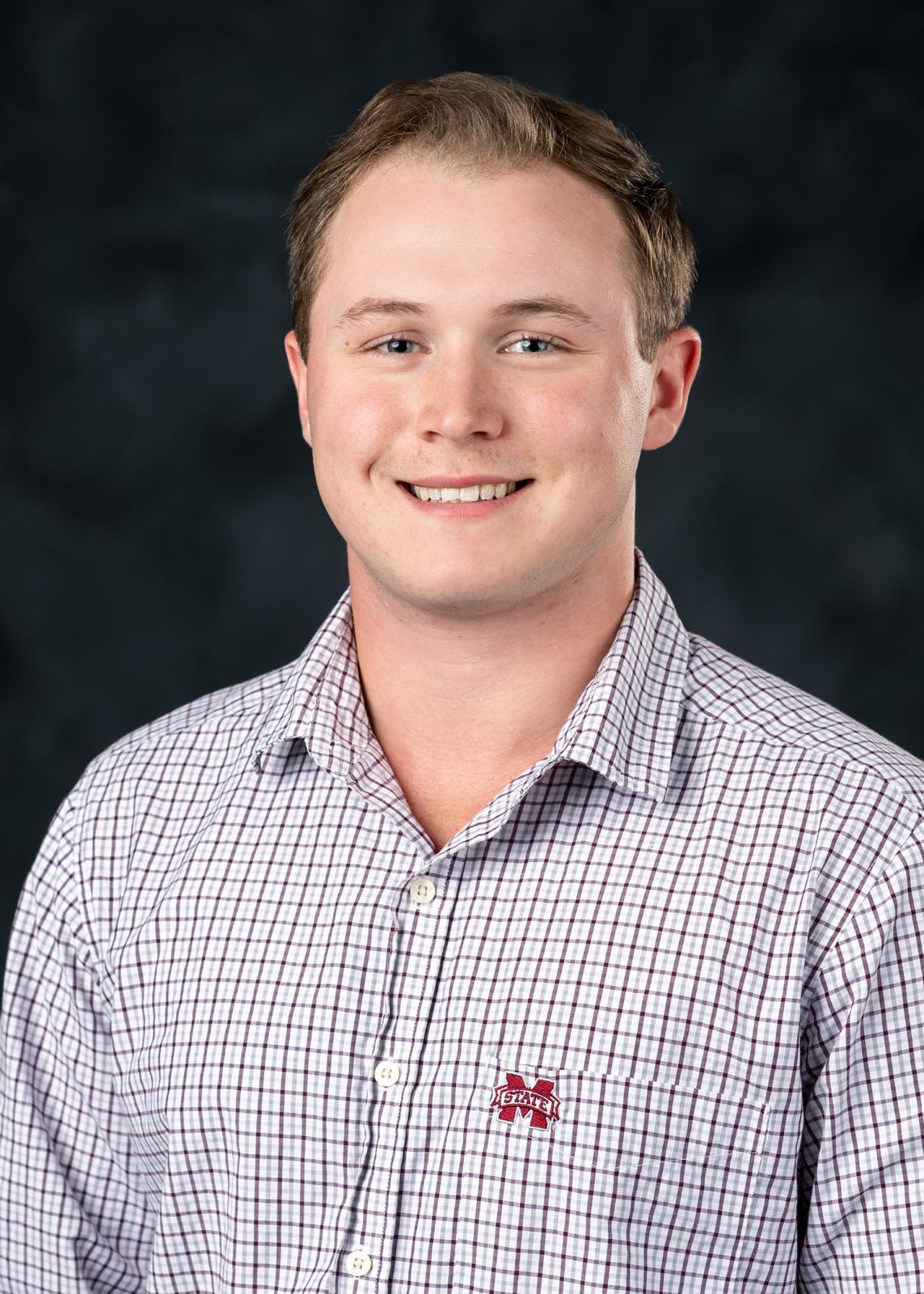 boy in MSU plaid shirt on black background