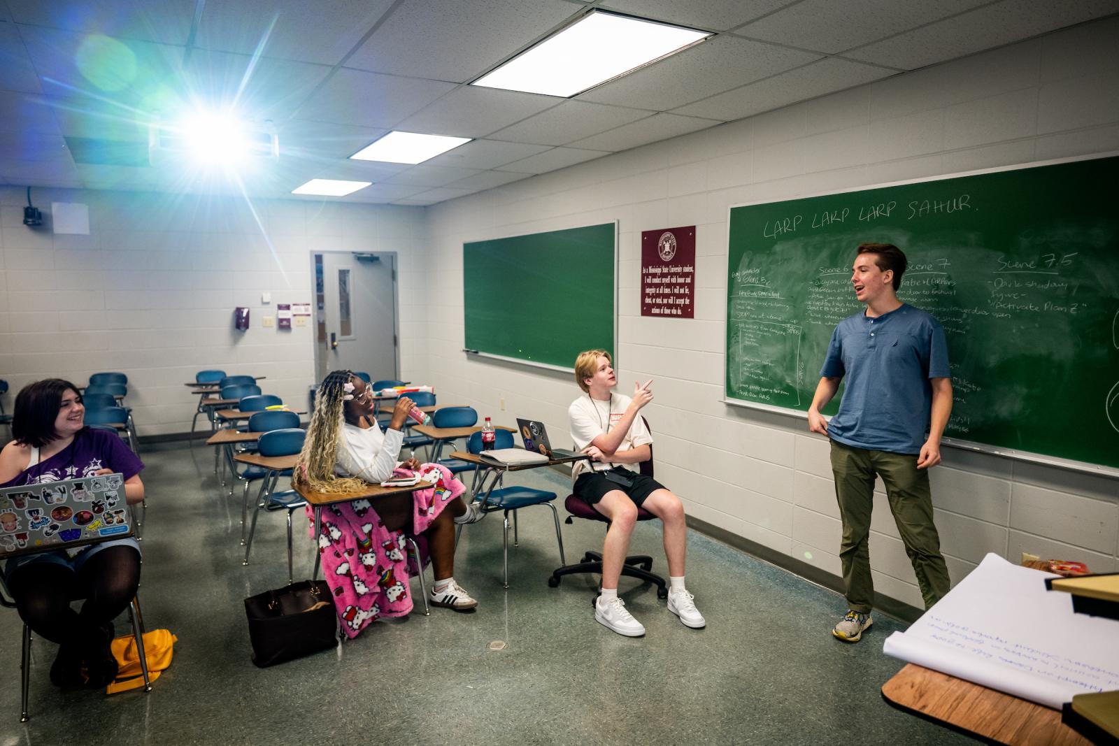 A group of Summer Scholars practice their screenwriting skills in a classroom with storyboarding