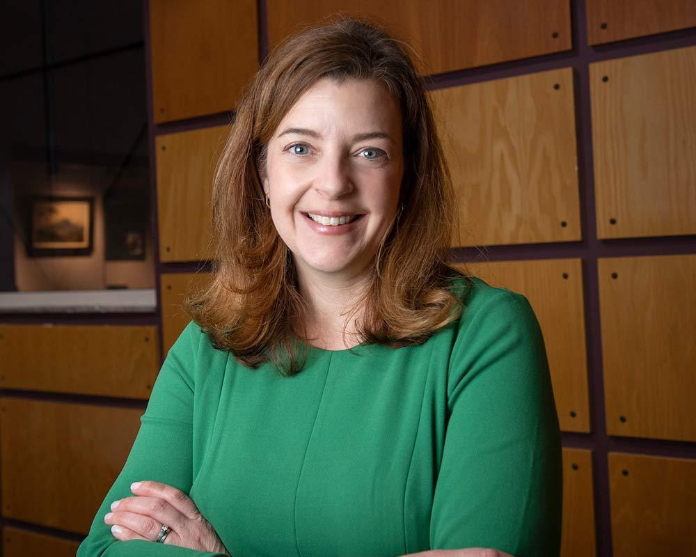 environmental portrait of Anne Marshall in a green dress at the Grant Library