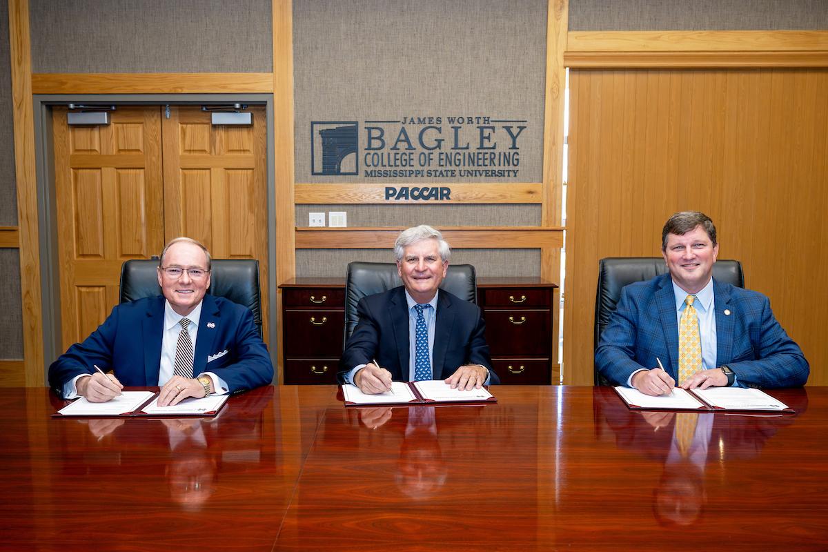 Photo of MSU president Dr. Keenum, Fred P. Burke and John Rush at a table.